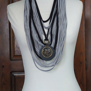 Nur ein Stück: Graue und schwarze Streifen mit großem Holzanhänger.