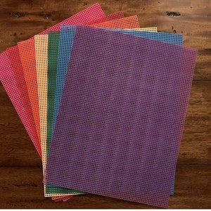 May include: A set of eight colorful plastic canvas sheets in various colors, including purple, blue, green, yellow, orange, and red. The sheets are stacked on top of each other, with the purple sheet on top.