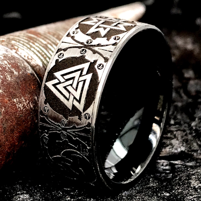 Peut inclure: Une bague noire et argent&eacute;e avec un design d&eacute;taill&eacute; repr&eacute;sentant un n&oelig;ud celtique et un symbole d'&eacute;clair. La bague est en acier inoxydable et a une finition polie.