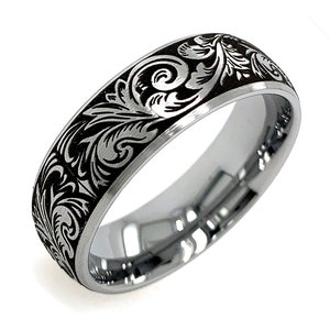 Puede incluir: Un anillo de metal plateado con un acabado pulido en el interior y una incrustaci&oacute;n negra en contraste en el exterior. La superficie negra est&aacute; grabada con un patr&oacute;n continuo de volutas florales de color plateado alrededor de la banda.