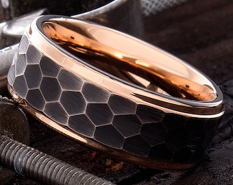 Op de afbeelding: Een zwarte ring van wolfraamcarbide met een roségouden band en een gehamerd zeshoekig patroon.