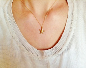May include: A gold chain necklace with a small gold starfish pendant.