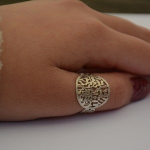 K&ouml;nnte beinhalten: Ein silberner Ring mit einem runden Design mit hebr&auml;ischen Buchstaben.