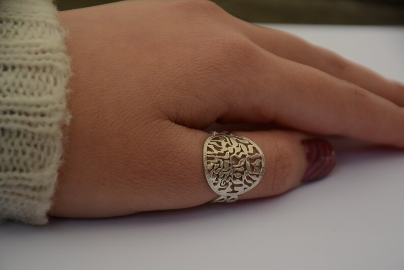 K&ouml;nnte beinhalten: Ein silberner Ring mit einem runden Design mit hebr&auml;ischen Buchstaben.