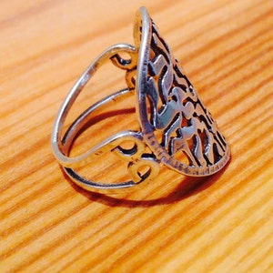 K&ouml;nnte beinhalten: Ein silberner Ring mit einem komplizierten, durchbrochenen Design. Der Ring ist tropfenf&ouml;rmig und hat ein zartes Filigranmuster.