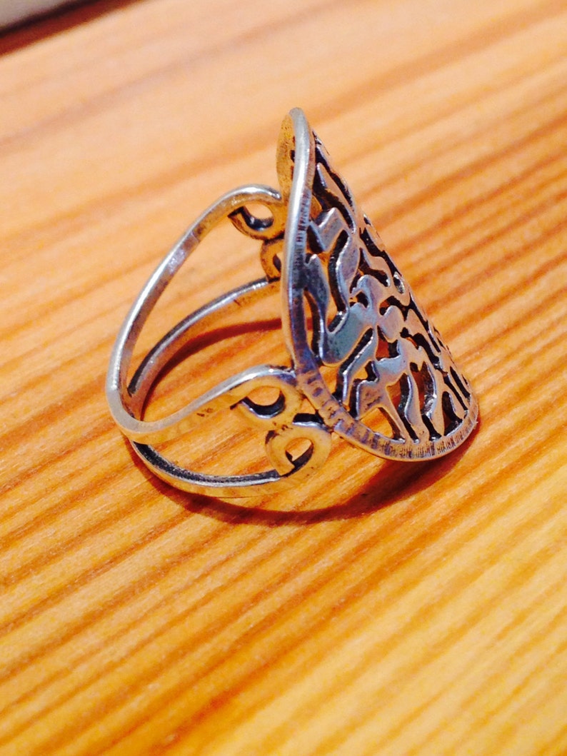 K&ouml;nnte beinhalten: Ein silberner Ring mit einem komplizierten, durchbrochenen Design. Der Ring ist tropfenf&ouml;rmig und hat ein zartes Filigranmuster.