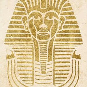 May include: A gold-colored illustration of an Egyptian pharaoh's mask. The mask is detailed with intricate lines and patterns.