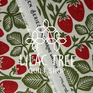 May include: Close-up of fabric with a repeating pattern of red strawberries, green leaves, and stems on a cream background. The text "GARDEN SERIES by Z. HARINE WATSON" and "LILAC TREE QUILT SHOP" is visible.