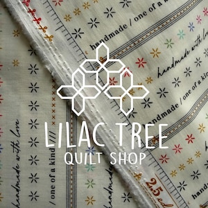 May include: A white ceramic mug with a black handle and the text "But First, Coffee" in a bold, black font. The mug is set against a blurred background, suggesting a cozy setting.