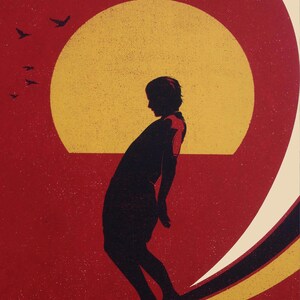 Pu&ograve; includere: Silhouette di una persona che fa surf contro un tramonto rosso e giallo. La persona &egrave; rivolta a sinistra e si trova nel mezzo di un'onda. Il sole sta tramontando sullo sfondo e ci sono uccelli che volano nel cielo.