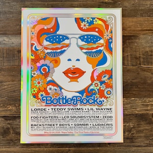 May include: A colorful poster with a retro design featuring a woman wearing sunglasses with a landscape reflected in the lenses. The poster has the text "BottleRock" and lists musical artists. The color palette includes orange, blue, and white.