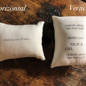 Puede incluir: Dos bolsas de tela blancas, una horizontal y otra vertical. La bolsa horizontal tiene el texto "Until the end of time..." impreso en ella. La bolsa vertical tiene el texto "THROW AWAY! "DO NOT EAT" DESICCANT SILICA GEL THROW AWAY! "DO NOT EAT" impreso en ella.