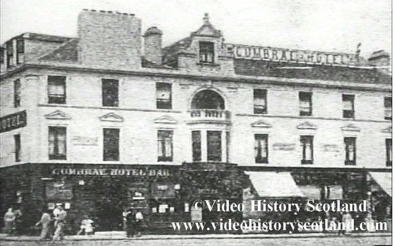 May include: A black and white photo of a building with the text "Cumbrae Hotel Bar" above the entrance. The building has a large arched window and several smaller windows. There are people walking in front of the building.