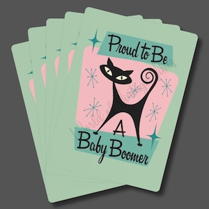 May include: A stack of mint green cards with a retro design. Each card features a black cat silhouette on a pink background, with the text "Proud to Be A Baby Boomer". The design includes starburst and geometric accents.