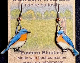 Pendientes de pájaro azul oriental de Jabebo, que inspiran curiosidad con cartón reutilizado de cajas de cereales.