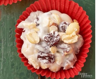 May include: White chocolate peanut butter candies with raisins in a red paper cupcake liner.