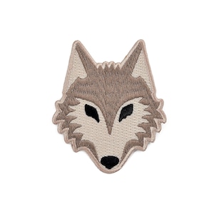 May include: Iron-on patch featuring an embroidered brown wolf's head with black eyes.