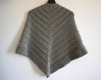 Könnte beinhalten: Ein grauer gestrickter Schal mit dreieckiger Form und einem strukturierten Muster.