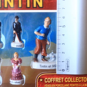 May include: A collector's set of Tintin figurines. The set includes several figurines of characters from the Tintin comic series, including Tintin, Snowy, and the detectives Dupont and Dupond. The figurines are painted in detail and are in a plastic display case.