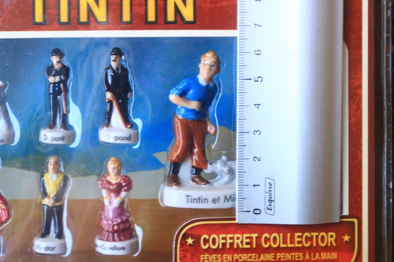 May include: A collector's set of Tintin figurines. The set includes several figurines of characters from the Tintin comic series, including Tintin, Snowy, and the detectives Dupont and Dupond. The figurines are painted in detail and are in a plastic display case.