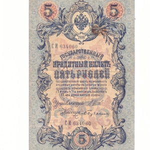 May include: A vintage Russian five ruble banknote from 1909. The note features an ornate design with a central image of the Russian Imperial Eagle. The text "ГОСУДАРСТВЕННЫЙ КРЕДИТНЫЙ БИЛЕТЬ ПАТЬ РУБЛЕЙ" is printed in red and black.