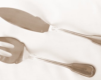 May include: A silver serving set with a knife and a three-pronged fork.