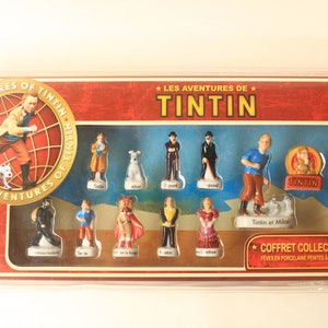 May include: A collector's set of porcelain figurines featuring characters from "The Adventures of Tintin." The set includes Tintin, Snowy, Captain Haddock, and other characters. The box has the title "The Adventures of Tintin."
