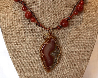 Dark red-orange agate beads knotted with 2 strands of leather necklace with a Brass wrapped red Geodal Agate pendant