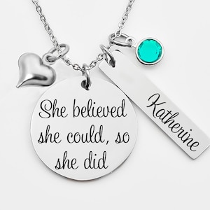 Pode incluir: Colar de prata com um pingente de coração, um pingente redondo com o texto "She believed she could, so she did", um pingente de barra com o nome "Katherine" gravado nele e uma pedra preciosa azul turquesa.
