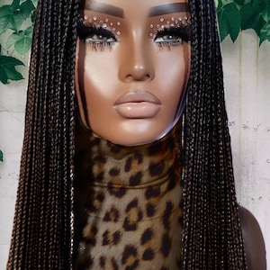 May include: A black braided wig with small beads woven into the braids. The wig is styled in long, straight braids that fall past the shoulders.