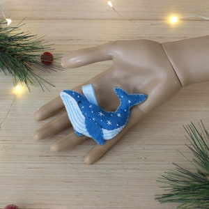 May include: Blue felt whale ornament with white snowflakes and a blue ribbon.