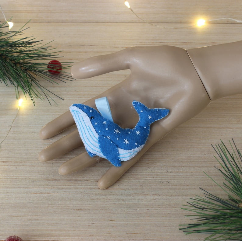 May include: Blue felt whale ornament with white snowflakes and a blue ribbon.