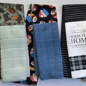 May include: Set of 8 kitchen towels with various designs. The towels are made of a soft, absorbent material and are perfect for drying dishes, wiping spills, and cleaning up messes. The designs include a school theme, a dog theme, a cupcake theme, a plaid theme, and a religious theme.