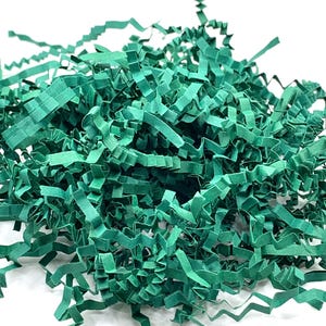 May include: A pile of teal green shredded paper, commonly used as packing material or for gift wrapping.