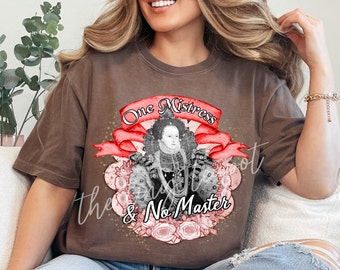May include: A brown t-shirt with a graphic of a woman in a crown and the text "One Mistress & No Master" in red and gold.