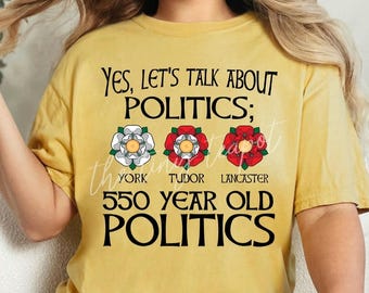 May include: A yellow t-shirt with the text "YES, LET'S TALK ABOUT POLITICS;" and three white roses with red centers. The roses are labeled "YORK", "TUDOR", and "LANCASTER". The text "550 YEAR OLD POLITICS" is below the roses.