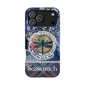 May include: A phone case with a navy blue background, featuring a dragonfly, flowers, and text. The design includes the words "Sing me a song of a lass that is gone" and "Sassenach" in white. The bottom has a plaid pattern.