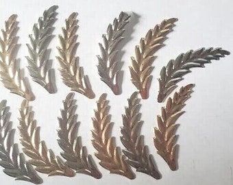 May include: Twelve gold-toned metal leaf sprigs with a textured finish. The sprigs are arranged in a random pattern on a white background.