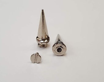 Puede incluir: Tres tachuelas de metal plateado en forma de pirámide con base de tornillo. Las tachuelas miden aproximadamente 2,5 cm de largo.