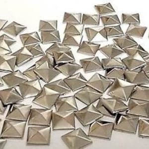 May include: A large quantity of silver pyramid-shaped studs. The studs are about 1/2 inch in size and have a flat back.