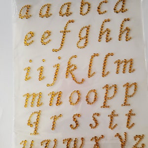 CraftbuddyUS 37 piezas autoadhesivas de 0.906 in, letras minúsculas doradas, diamantes de imitación