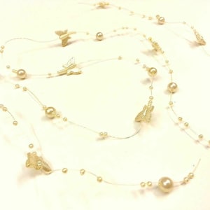 May include: A string of white pearls and gold butterflies, perfect for decorating a wedding or party.