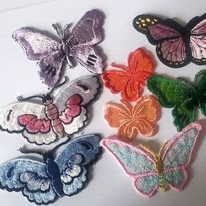 May include: Assortment of colorful iron-on butterfly patches in various sizes and designs. The patches include purple, pink, orange, green, and blue butterflies.