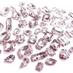 May include: Assortment of clear crystal rhinestones in various shapes and sizes, perfect for crafting and embellishing projects.