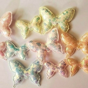 May include: Assortment of colorful butterfly-shaped sequins, perfect for crafting and embellishing projects. The sequins are made of iridescent material and come in a variety of sizes.