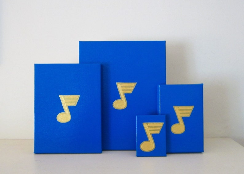 May include: Four blue boxes of different sizes with gold musical notes painted on them. The boxes are arranged in a pyramid shape.