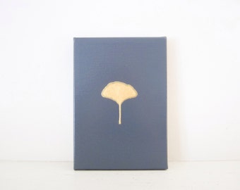 May include: A gray canvas painting with a gold ginkgo leaf design.