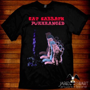 May include: Black t-shirt with a pink and blue graphic of cats in a line with the text "Eat Sabbath Purrkranoid" in pink and red.