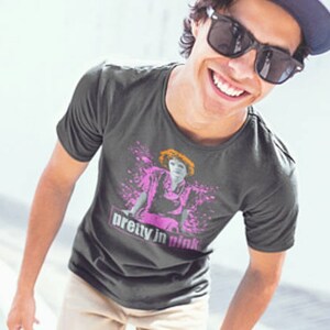 May include: A dark gray t-shirt with a graphic print of a woman in a pink dress and the text "pretty in pink".