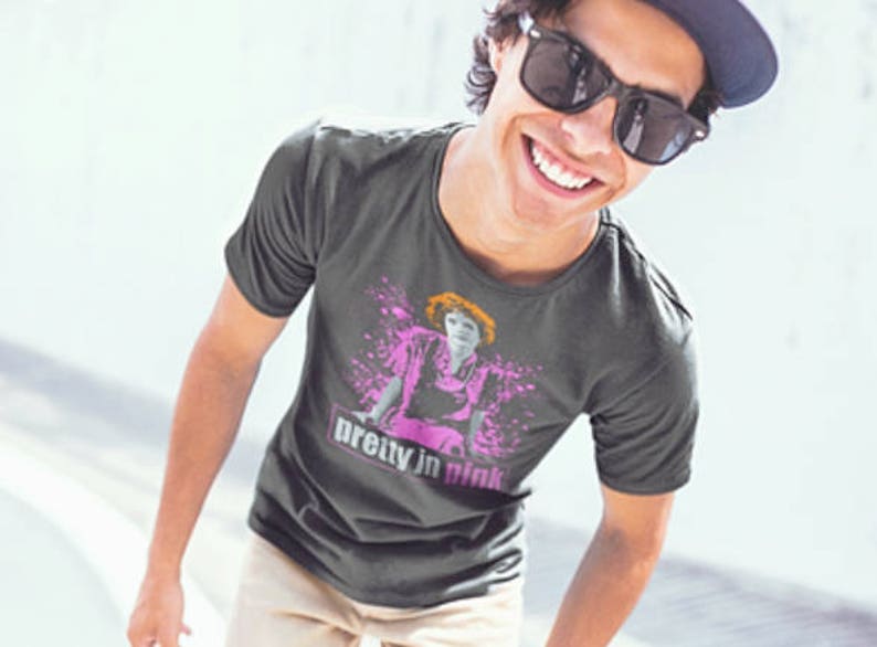 May include: A dark gray t-shirt with a graphic print of a woman in a pink dress and the text "pretty in pink".